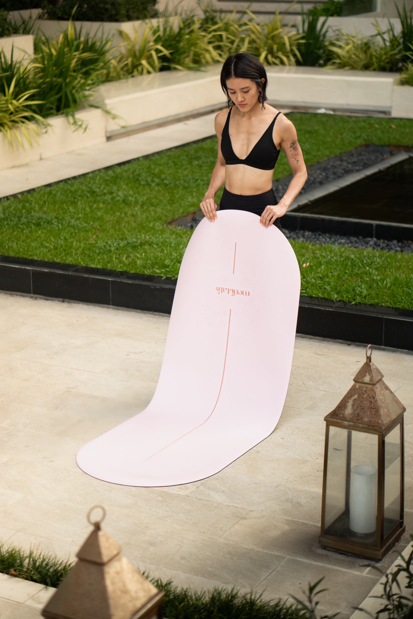 Frau rollt die COTTON CANDY medi.mat Yogamatte in Rosa aus – stilvolles Yoga-Accessoire in ikonischer Kapselform.