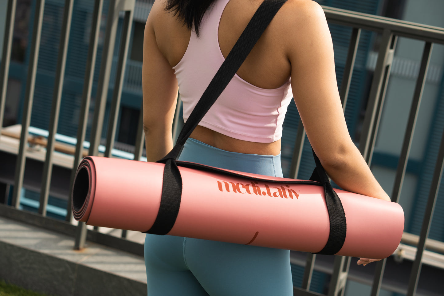 Yogamatte mit Tragegurt über der Schulter – stilvoller Begleiter für unterwegs und deine tägliche Praxis.
